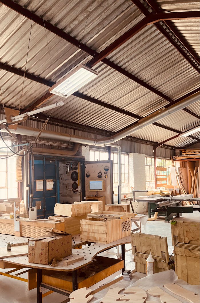 services-02 Sunlit workshop filled with wooden craft materials and workbenches in a rustic setting.