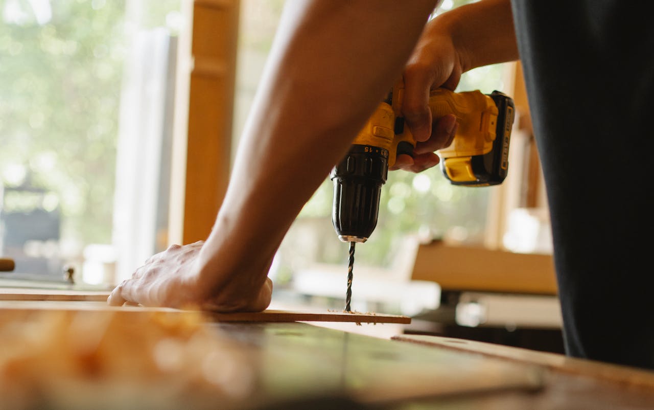Mastering the First Impression: Your intriguing post title goes here Close-up of a person using a power drill on wood indoors during daytime.